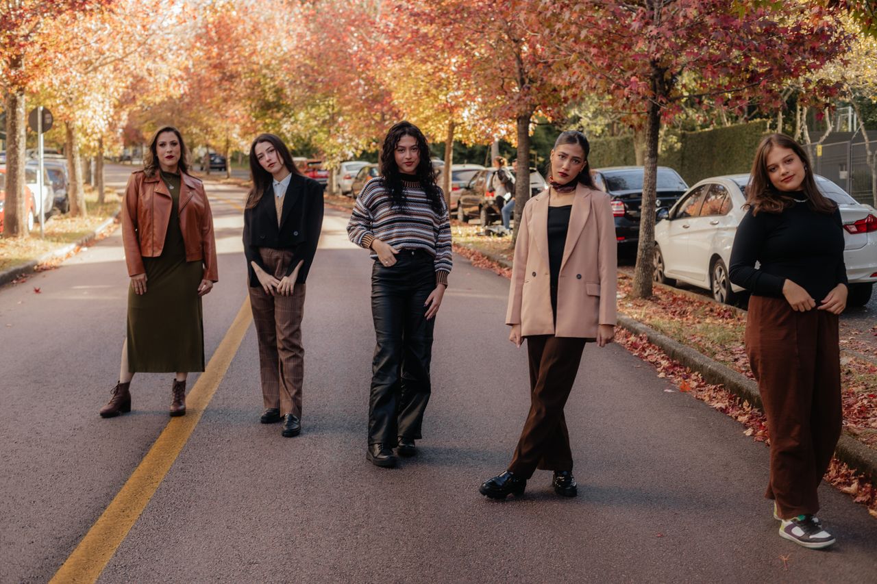 Mastering the First Impression: Your intriguing post title goes here Group of women posing on a city street with autumn foliage, showcasing fashion.