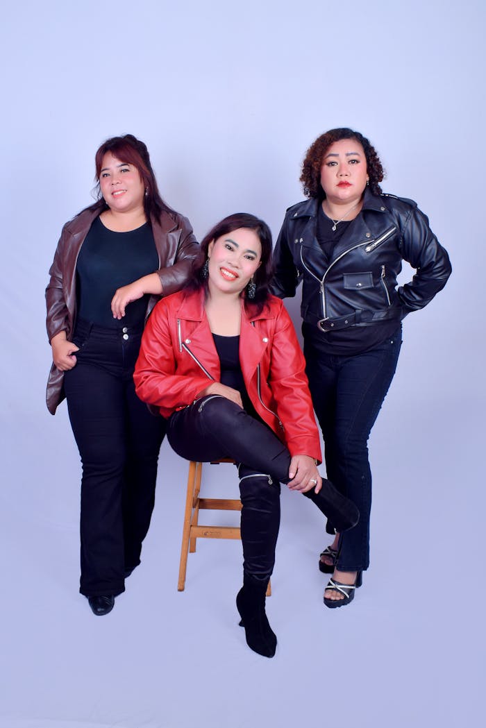 about-img Three confident women posing together in leather jackets against a studio backdrop.